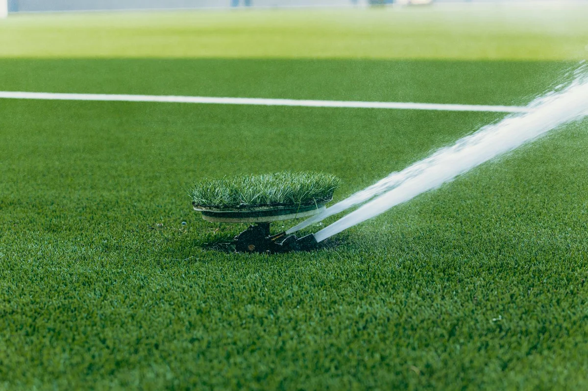 Lawn sprinkler watering green grass in Winnipeg — No-BS Yardwork